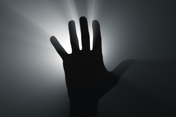 在聚光灯下举手。图片下载