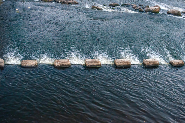 水坝附近河里的石头。照片图片下载