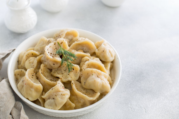 手工饺子与肉放在白色的餐桌上，传统俄罗斯料理，横放，放置文字图片下载