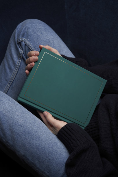 女人坐着看书。拿着绿皮书的年轻女子图片下载