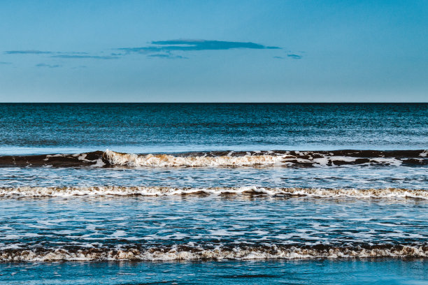 在一个阳光明媚的周末，在清新的空气中，在岸边冲浪。图片下载