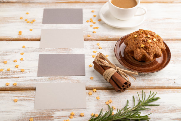 灰色纸名片模型与咖啡杯和蛋糕在白色木制背景。空白，侧视图，静物。图片下载