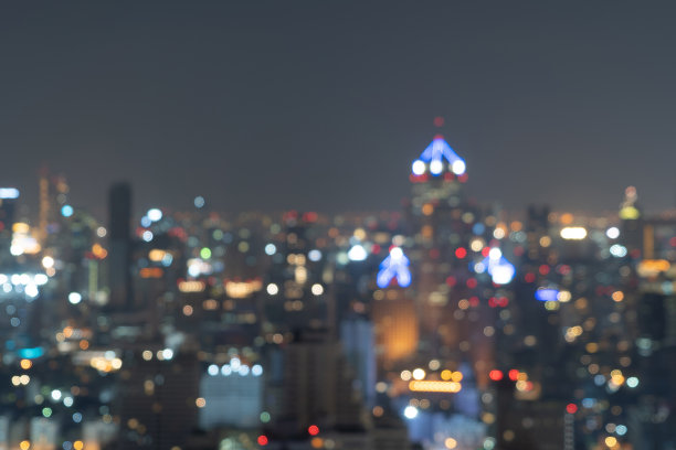 虚景抽象背景的摩天大楼在曼谷市，泰国与灯光，模糊的照片在晚上的时间。城市景观。图片下载