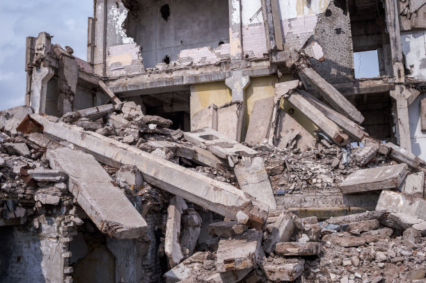 前景是一座废墟建筑的遗迹，上面有很大的地基桩。背景图片下载