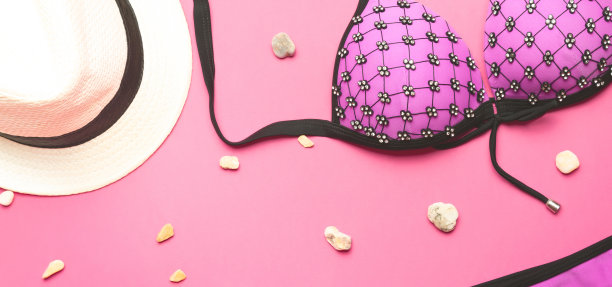 旅行的概念。夏日女性配饰帽子、泳装、泳装以粉色为背景，夏日沙滩度假、平躺、俯视图。图片下载