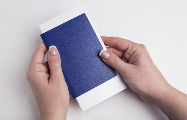 女人手里拿着蓝色的护照。白色背景的人体免疫护照。图片下载