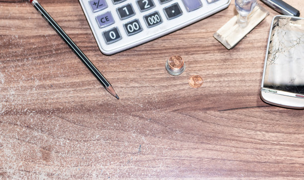 办公用品，计算器，尺子，笔和笔记本，放在木纹桌子上，从俯视图，并有空余空间。图片下载