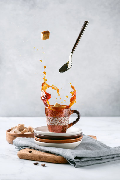 一杯咖啡。勺子和糖悬浮。溅的咖啡。图片下载