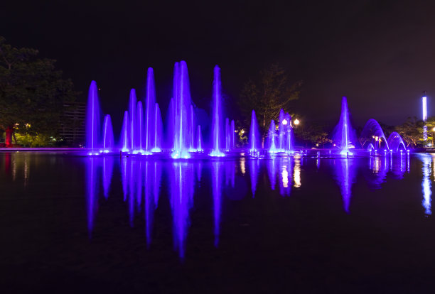 五颜六色的喷泉展示用明亮的紫色照亮了黑暗的夜空图片下载