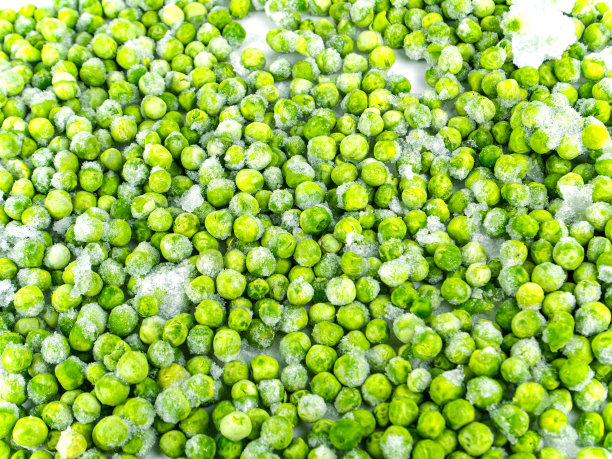 白色盘子里放着冷冻的绿豌豆。图片下载