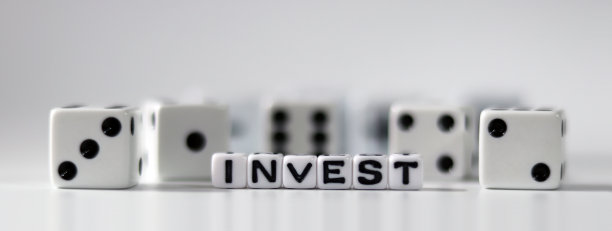 “投资”这个词用在白色的方块和白色的骰子上。企业财务和投资概念。图片下载