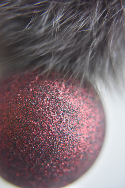 选择性聚焦在表面有闪光的红球上。复制空白的白色背景与灰色毛皮图片下载