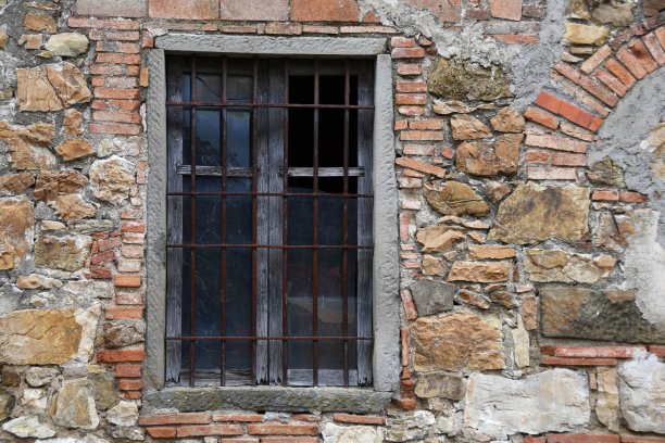 这是意大利托斯卡纳乡村一座废弃的破旧石屋的玻璃破碎的窗户图片下载