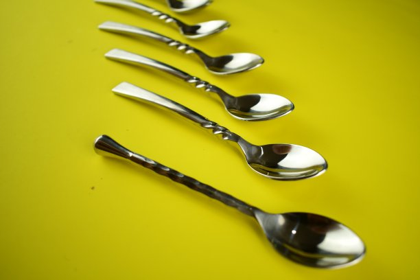 亮黄色背景上的银勺图片下载