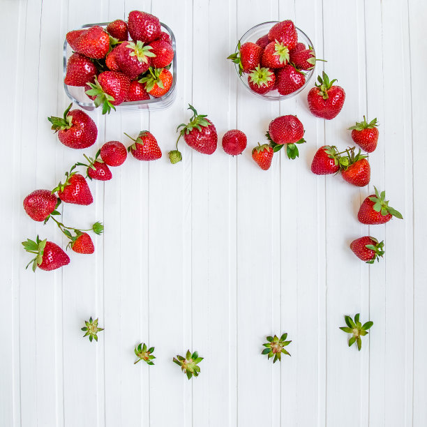 白底上的碗里装着新鲜的草莓。图片下载