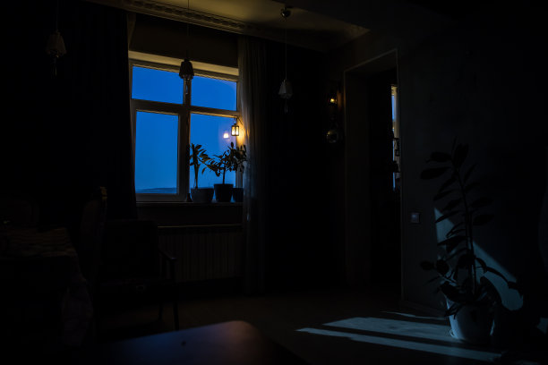 从黑暗的房间透过窗户看到的月亮的夜景。月光在暗室里。长时间曝光拍摄图片下载