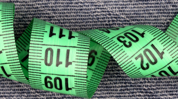 在彩色的织物背景上用卷尺测量图片下载