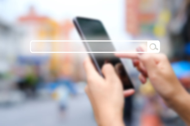 空白搜索栏上模糊的图像。浏览互联网信息的女人的手。图片下载