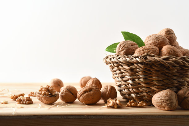 装满核桃的篮子放在木桌上孤立背景图片下载