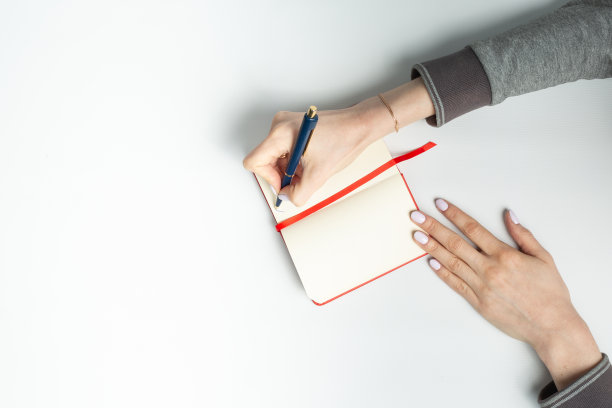 特写的女人的手写在笔记本放在一个白色的背景。国家笔迹日图片下载