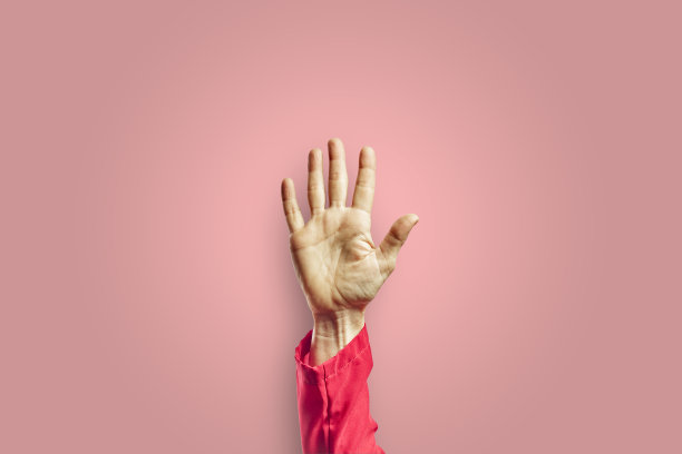 在粉红色的背景下，女人张开手做手势图片下载