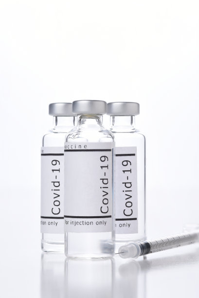 三瓶Covid-19疫苗和注射器，白色反光。图片下载