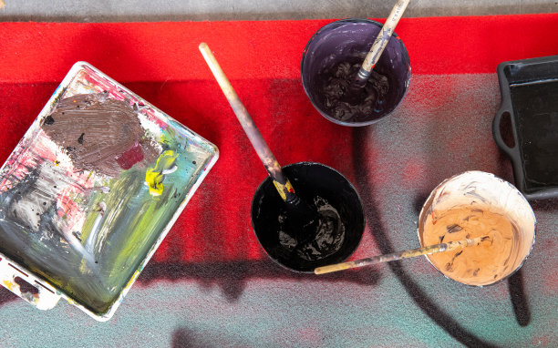 艺术调色板和容器与油漆和刷近距离在艺术工作室的地板上图片下载