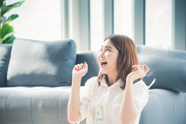 快乐年轻的亚洲女人拿着美元钱，扔在空中庆祝幸福舞蹈财富彩票钱雨点。胜利者成功的商人女人扔现金流快乐的钱笑脸图片下载