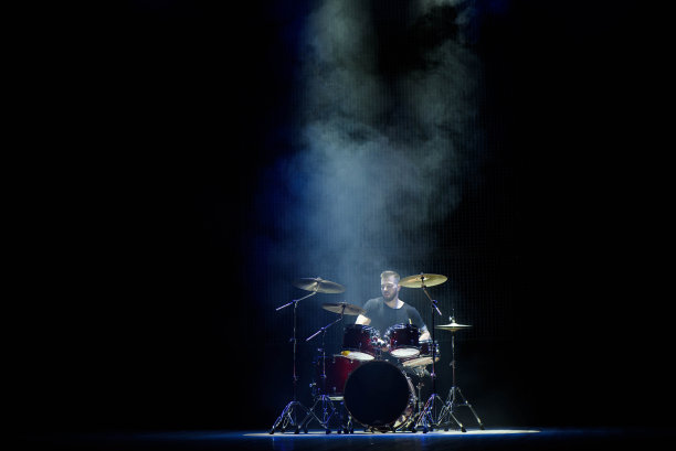 音乐，人，乐器和娱乐概念-男性音乐家用鼓槌在舞台上打鼓图片下载