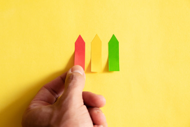 一只手挑选黄色背景上的红色负面评论贴纸图片下载