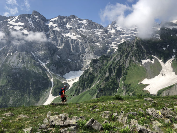 一名越野者在薄雾中攀登高山草地图片下载