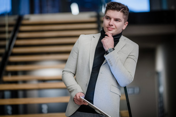 渴望成功的年轻商人在办公大楼里。一幅年轻商人使用数码平板电脑的肖像。图片下载