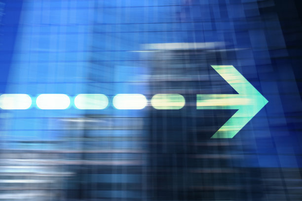 模糊的办公楼和绿箭。图片下载