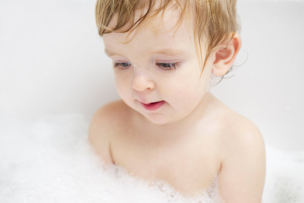 快乐的孩子在浴缸里享受泡沫浴的乐趣。可爱快乐的男孩享受洗澡时间在浴缸里溅水，宝宝洗澡的概念。图片下载