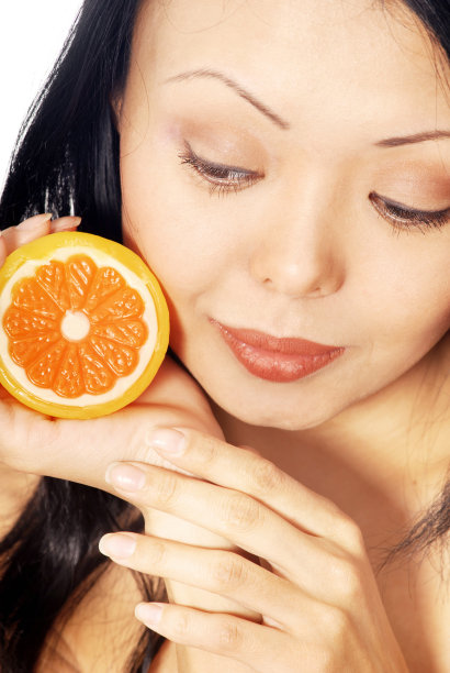 特写照片的漂亮女人与一个橙子图片下载