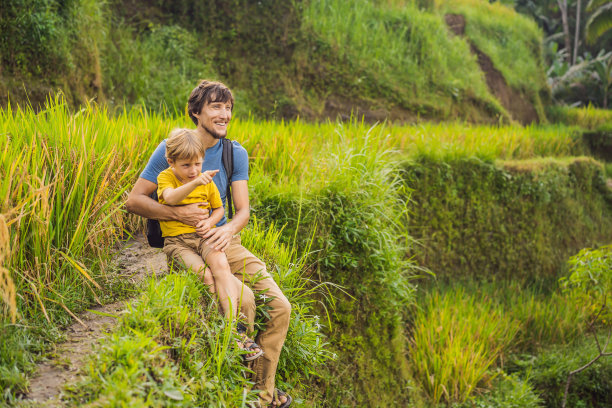 父亲和儿子旅行者在美丽的水稻梯田背景下的著名火山在巴厘岛，印度尼西亚旅游与儿童的概念图片下载