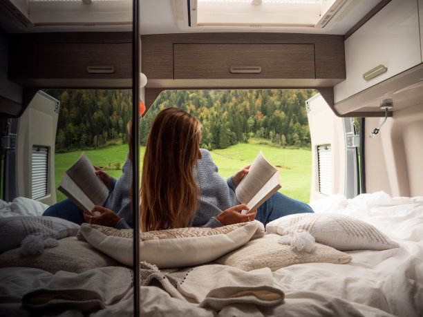 宁静的女人在一辆俯瞰高山风景的货车里看书图片下载