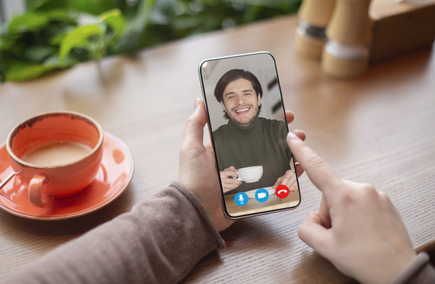 一名女子在咖啡馆用智能手机与丈夫在线视频通话图片下载
