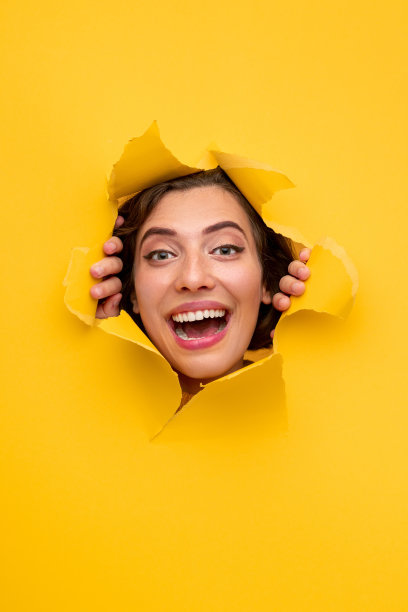 兴奋的女人透过纸上的洞看图片下载