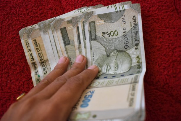 500印度货币在手，红色背景图片下载