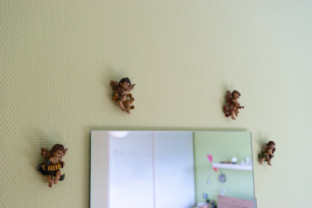 四个天使乐师挂在墙上的一面镜子周围。图片下载