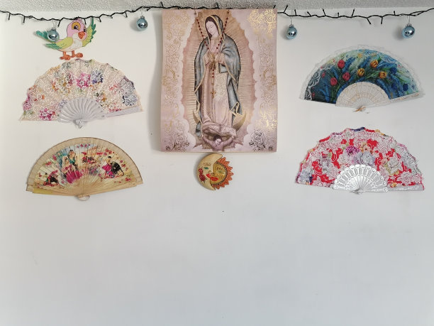 白色墙壁上瓜达卢佩的处女照片，周围有扇子图片下载