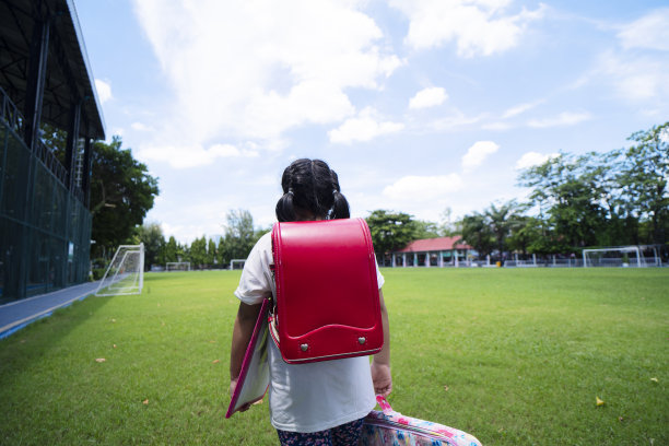 小女孩背着背包去上学。后视图图片下载