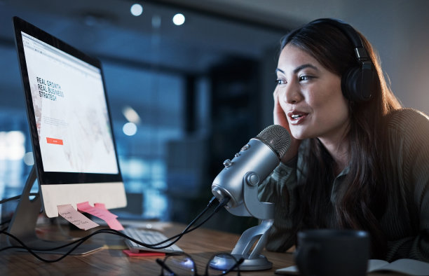 一个女人晚上坐在办公室里做广播的照片图片下载