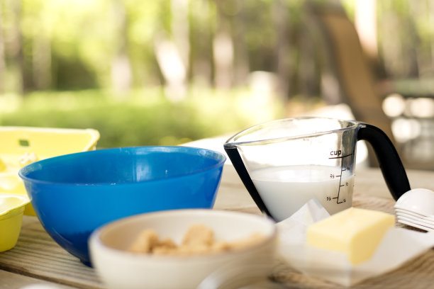 户外烹饪：家人在野餐桌旁准备食材图片下载