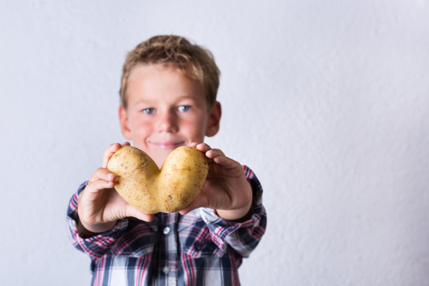 新潮丑蔬菜，心形土豆在手中图片下载