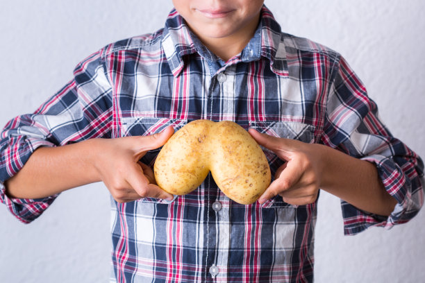 时髦丑陋的蔬菜，手捧人形肺形的土豆图片下载
