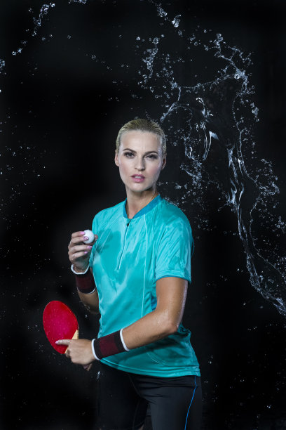 职业女子网球运动员湿装与红色球拍对着水滴在黑色背景。垂直拍摄图片下载