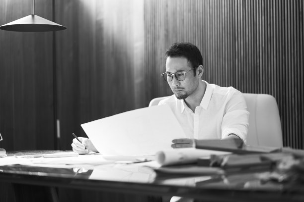 亚洲胡子设计师坐在室内，思考和草图的想法图片下载