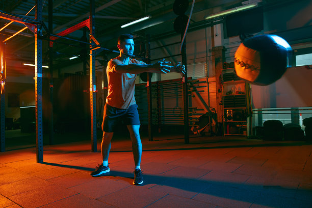 年轻的运动员，健身教练在混合霓虹灯光下训练。图片下载